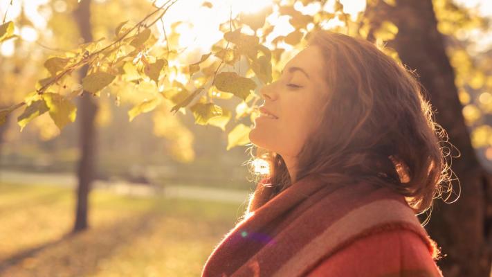 Frau genießt Sonne im Herbst