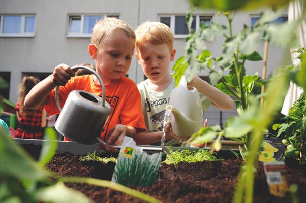 Buben gießen ein Gartenbeet