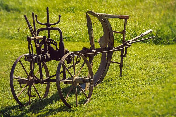 historischer Pflug auf einer grünen Wiese