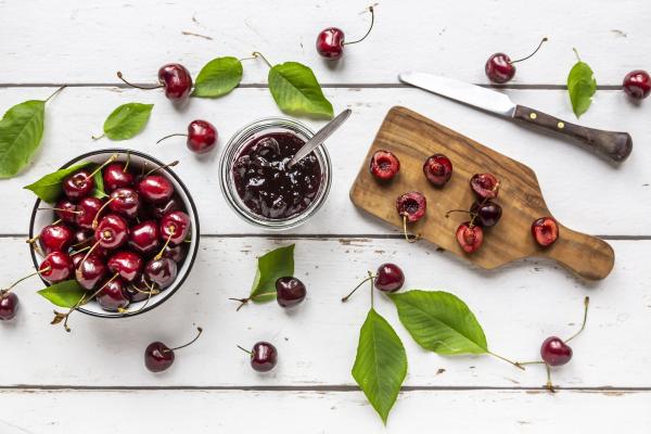 Kirschenmarmelade und Kirschen auf einem Tisch