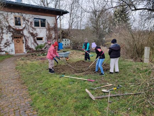 Kinder säen eine Wildblumenwiese