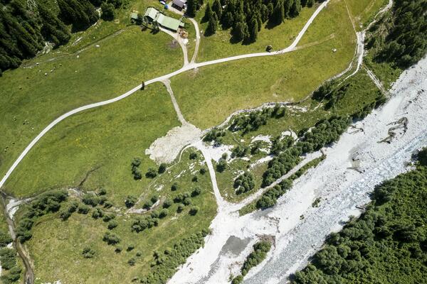 Luftbild einer Alm und eines Flusses