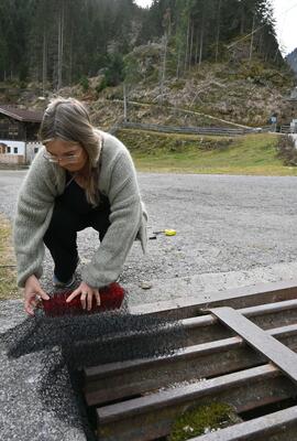 Frau steckt Amphibienleiter durch den Weiderost