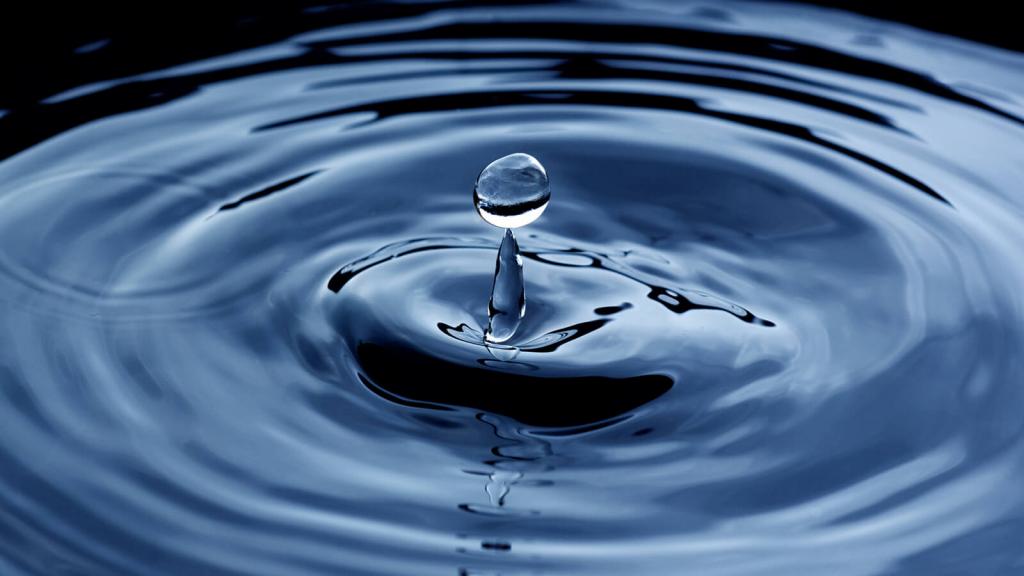 Splashing blue water drop close up background