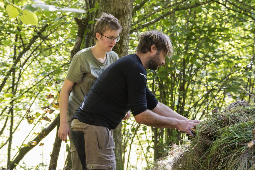 Wildniskurs Basic: Außenisolierung wird auf Trümmerhütte aufgebracht © Uwe Grinzinger Wildniskurs Basic: Außenisolierung wird auf Trümmerhütte aufgebracht