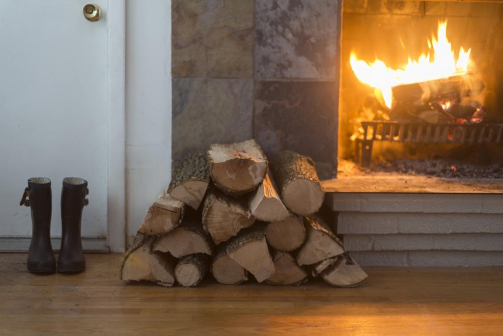 Feuer in offenem Kamin mit aufgeschlichteten Holzscheiten