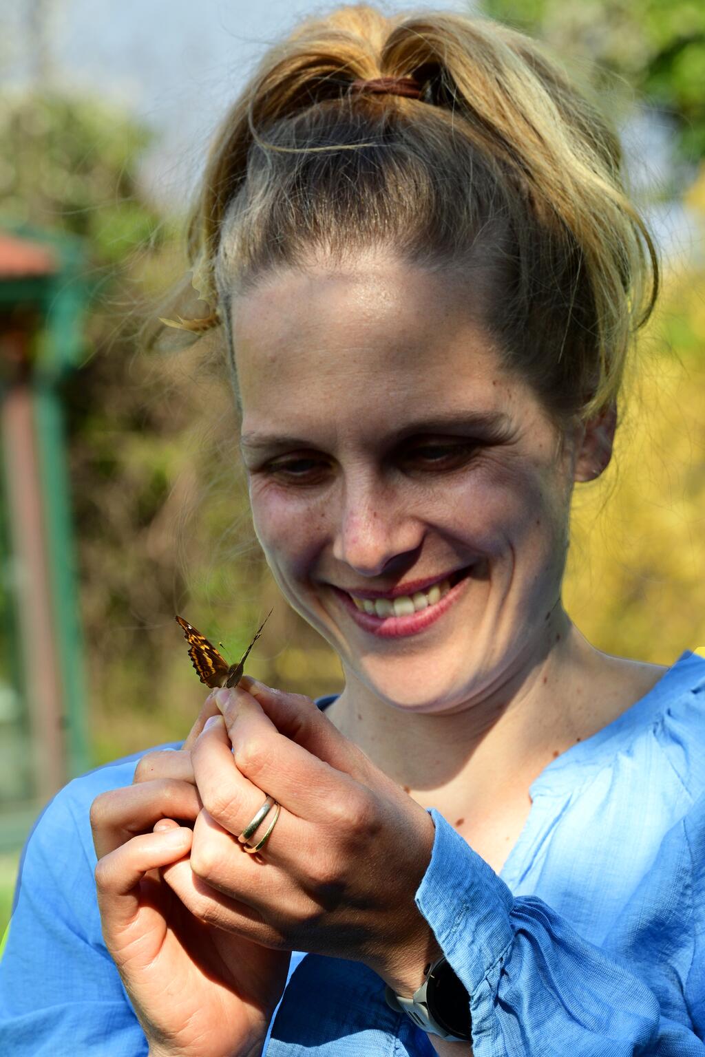 Frau hält Schmetterling in der Hand