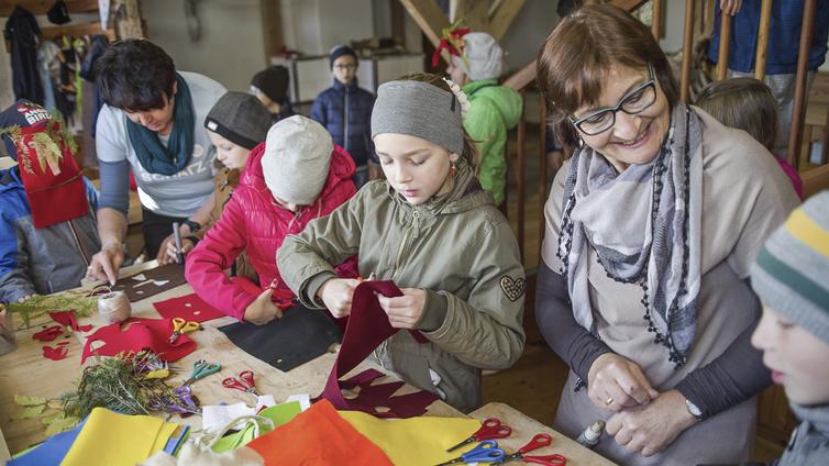 Kinder basteln in der Werkstatt Masken aus Filz und Naturmaterialien.