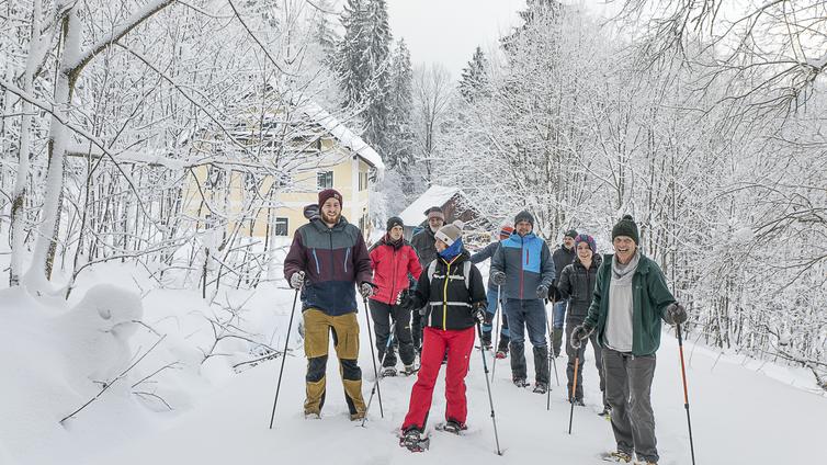 Feuer und Eis © NATURSCHAUSPIEL, Thomas Reibnegger Eine Gruppe von Schneeschuh-Wanderern im tief verschneiten Wald vor der Böhmerwaldschule.