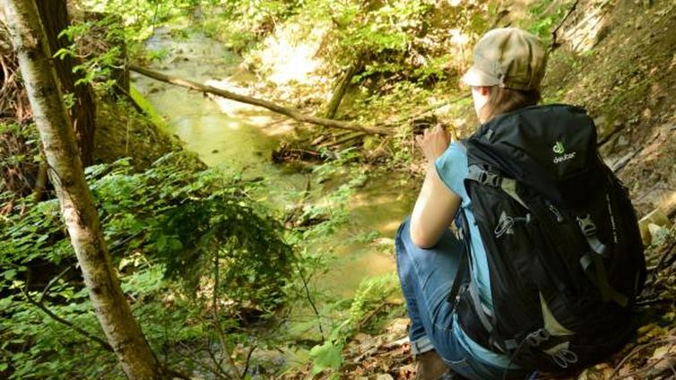 Frau am Bach sitzend