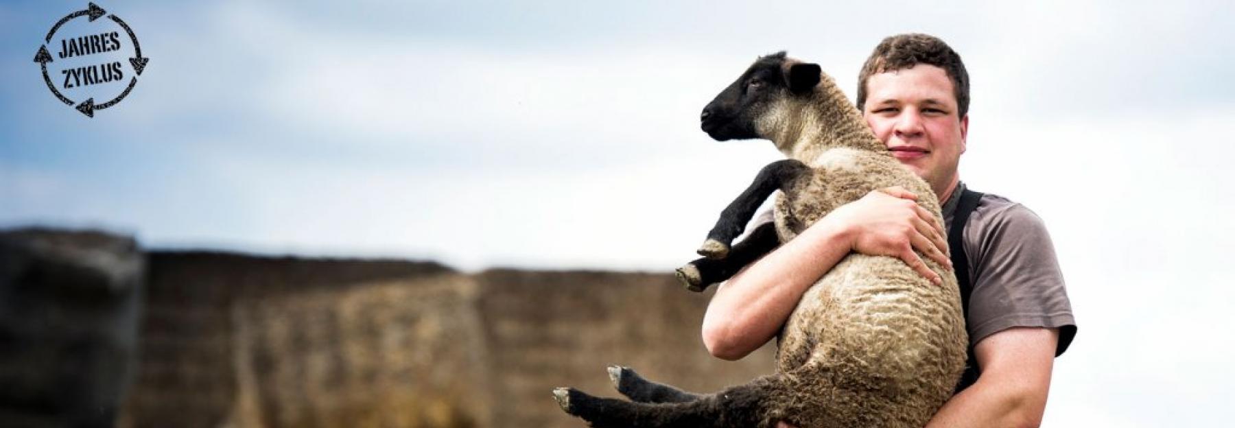 Mann hält Schaf in den Armen