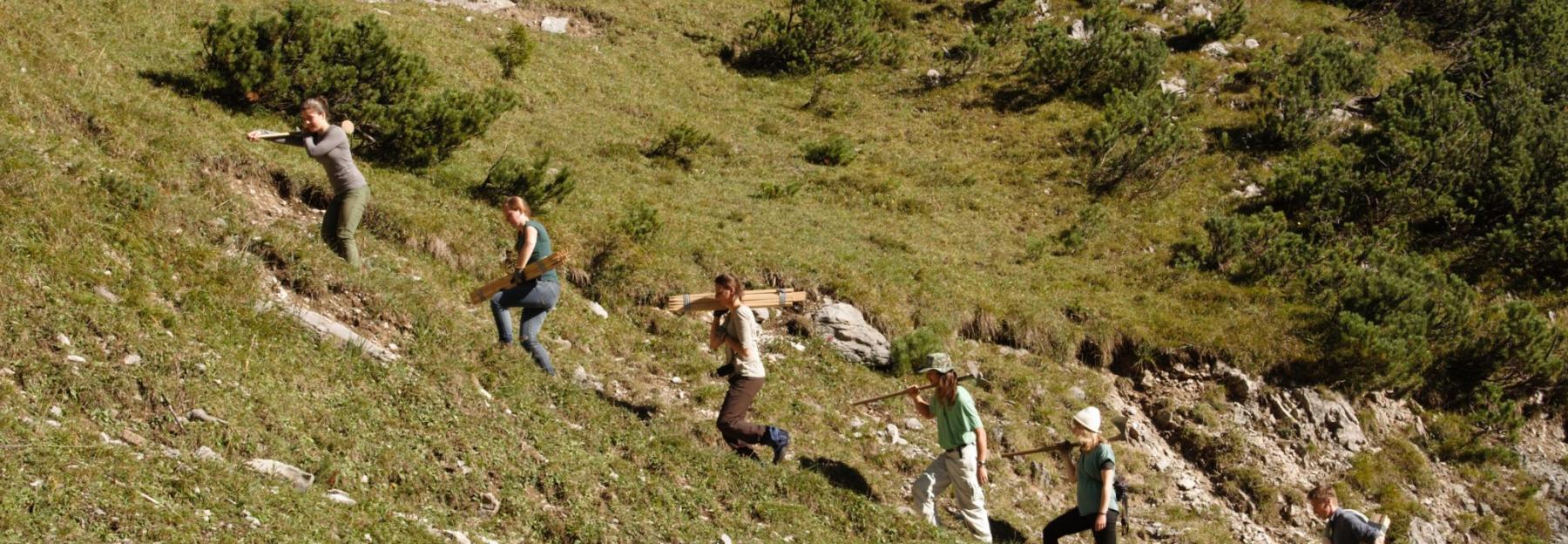 Freiwillige steigen auf den Berg zu ihrer Einsatzstelle