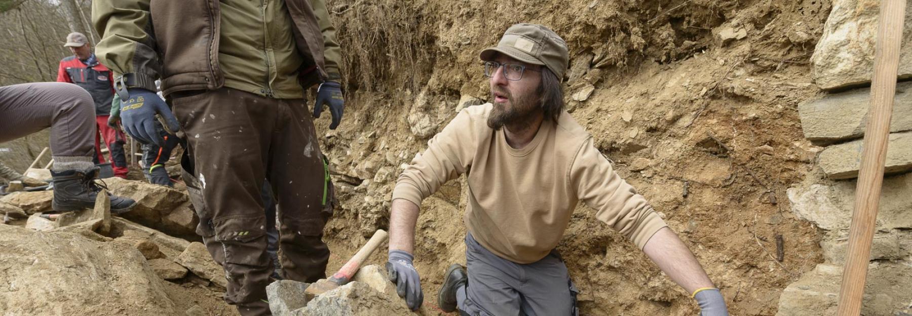 Menschen bauen eine Trockensteinmauer