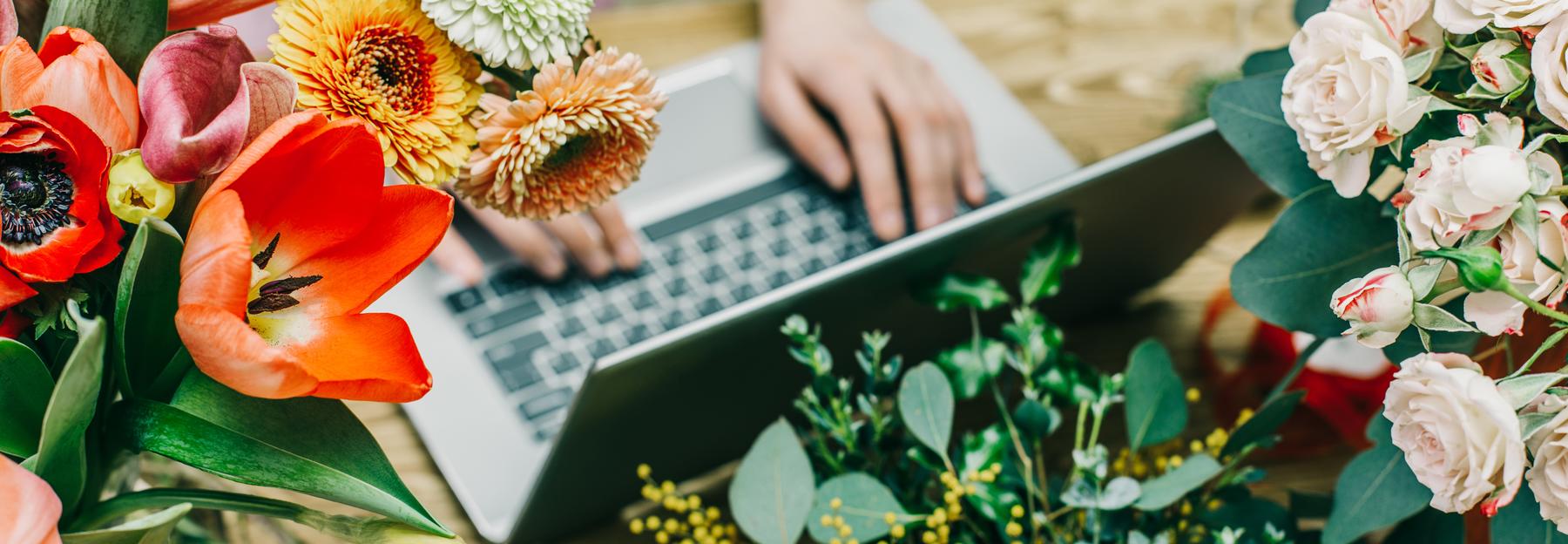 Notebook umgeben von bunten Blumen