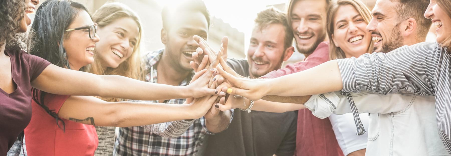 Junge Menschen geben die Hände zusammen, Teamwork