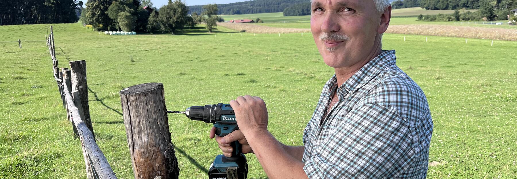 Gerhard Moser bei der Arbeit – mit dem Akkubohrer schafft er entlang der Weidezäune wertvolle Nistplätze.