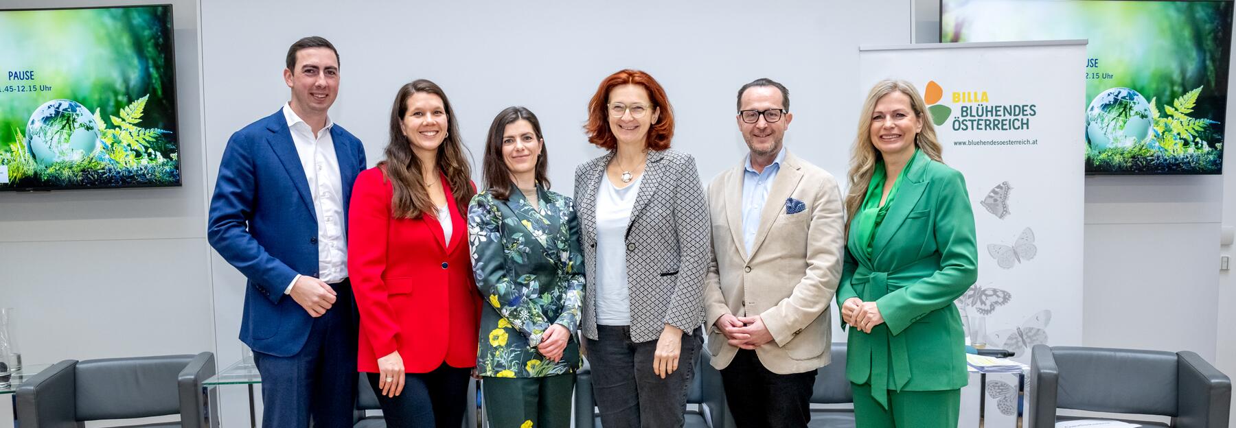 Sechs Personen stehen auf einer Bühne und schauen in die Kamera