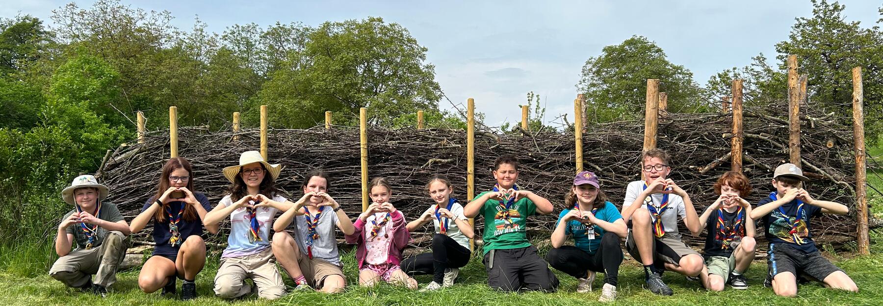 Kinder und Erwachsene zeigen ein Herz mit ihren Händen