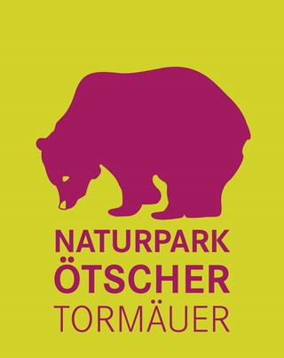 Logo Naturpark Ötscher-Tormäuer, Bär (Magenta) auf gelbem Grund