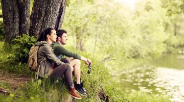 Österreichs Naturschätze entdecken © Syda Productions/Shutterstock.com Paar im Grünen am Fluss Shutterstock