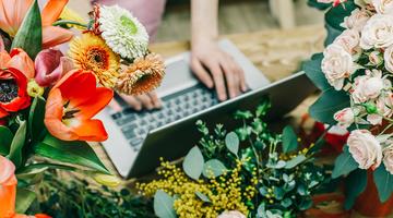 Notebook umgeben von bunten Blumen