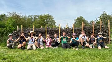 Kinder und Erwachsene zeigen ein Herz mit ihren Händen